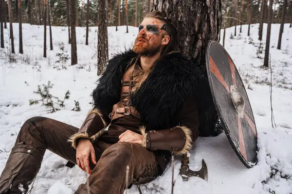 Vikingakrigare Med Krigsmålning Ansiktet Vilar Mot Ett Träd Snön Synes Stockbild