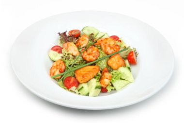 Izgara karides, taze salatalık, vişneli domates ve karışık yeşillik içeren canlı bir salata.