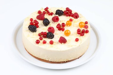 Beyaz bir tabakta servis edilen taze böğürtlenli leziz cheesecake.