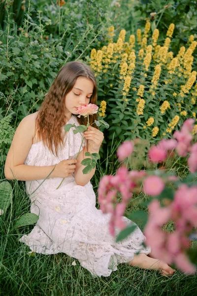 Genç Bir Kız Elinde Gülle Çiçek Açan Bir Bahçede Çimlerin — Stok fotoğraf
