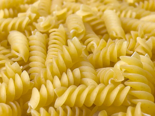 食品の背景やテクスチャは スパイラルの形で乾燥イタリアのパスタを生 閉じる マクロ 上のビュー 調理されないマカロニ — ストック写真