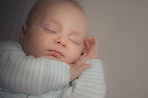无忧无虑地睡在房间里的小男婴床上 安静的孩子闭着眼睛躺在床上 肖像画 图库图片
