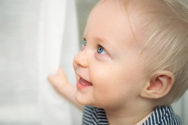 可爱的宝宝与蓝眼睛 特写肖像 小男孩在家里望着远方 图库照片