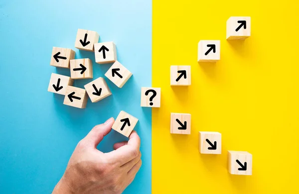 Stock image Hand choosing a block with arrows. Path leads to successful decision concept.