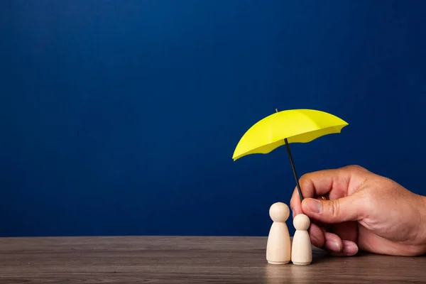 傘を持って家族を覆う手 生命保険コンセプト ロイヤリティフリーのストック写真