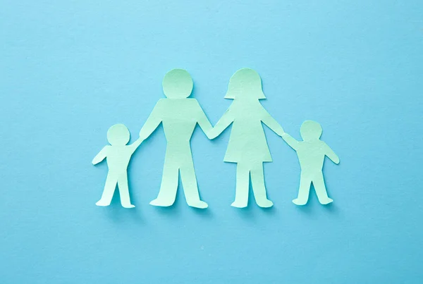 Life insurance concept. Paper cutout of family (father, mother, son and daughter)