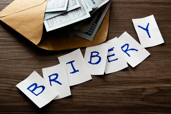 stock image Money and the words of Bribery. Concept of Bribery