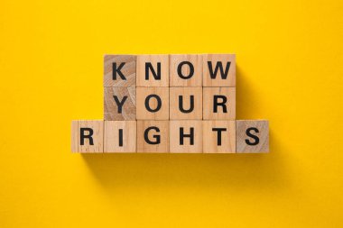 Tahta bloklar sarı arka planda insan hakları ve sosyal adaleti temsil eden haklarınızı biliyor.