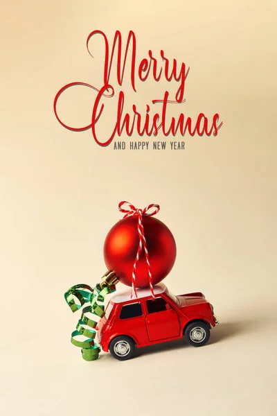 クリスマスや新年のグリーティングカードを祝うための最小限のデザイン ギフト配送のコンセプト 小さな赤いおもちゃの車と明るい背景の赤いクリスマスボール — ストック写真