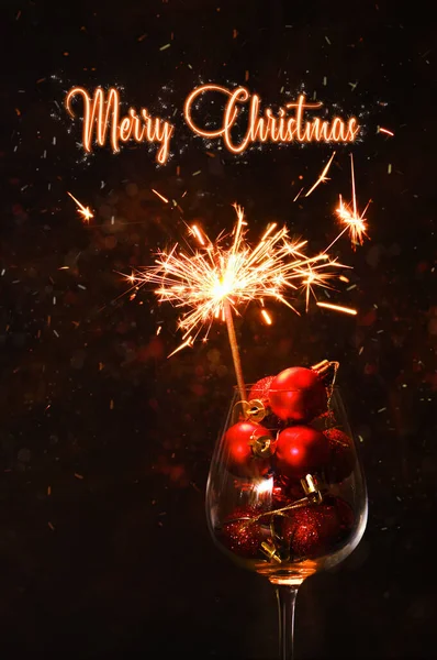 Vrolijk Kerstfeest Wijnglas Met Rode Kerstballen Brandende Schittering Feestelijke Nacht — Stockfoto