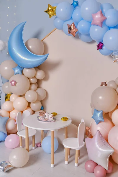 Children\'s photo zone with a lot of balloons. Decorations for boys and Girls Birthday party. Concept of children\'s birthday party. Cream-colored and pink balls.