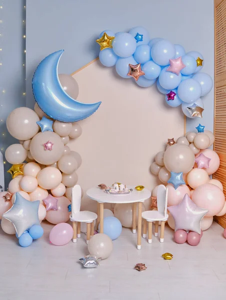 Children's photo zone with a lot of balloons. Decorations for boys and Girls Birthday party. Concept of children's birthday party. Cream-colored and pink balls.