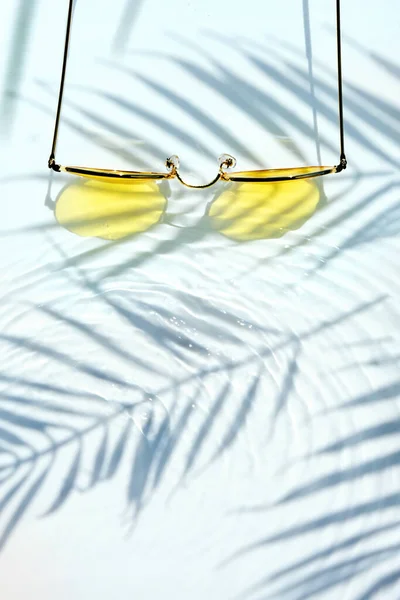 여름의 바닥에는 야자나무 그림자와 노란색의 선글라스가 있었다 해변에서의 여름무더운 — 스톡 사진