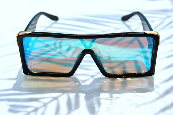 Stílusos Napszemüveg Tükrözött Szemüveggel Fekszik Víz Hátterében Egy Pálmafa Árnyéka — Stock Fotó