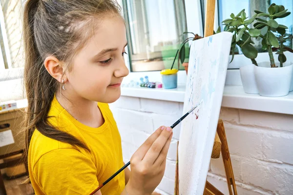 可愛い可愛い女の子の子供がイーゼルに描かれています 自宅で絵画の訓練 子供の創造性 幸せな子供時代 子供の創造性 絵画プロセスのクローズアップショット — ストック写真