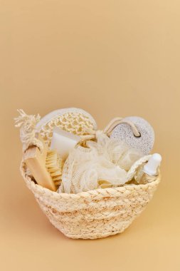 Hasır sepetin içinde banyo aksesuarları hazır. Sürdürülebilir kişisel hijyen malzemeleri, bej arka planda sağlık hediyesi.