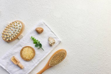 Kozmetik, masaj ve banyo aksesuarları beyaz doku arka planında, beyaz çiçek, yeşil yapraklar. Kozmetik modeli. Düz görünüm kopyalama alanı yatıyordu. Marka ürünleri, güzellik geçmişi