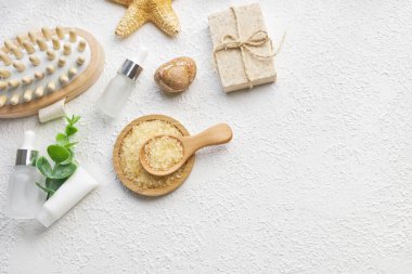 Masaj, spa ve banyo aksesuarları beyaz desenli arka plan, beyaz çiçek, yeşil yapraklar. Kozmetik modeli. Düz görünüm kopyalama alanı yatıyordu. Marka ürünleri, güzellik geçmişi