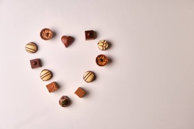 Kalp şekli, beyaz bir masanın üzerinde çeşitli çikolatalı mantarlardan yapılmış.
