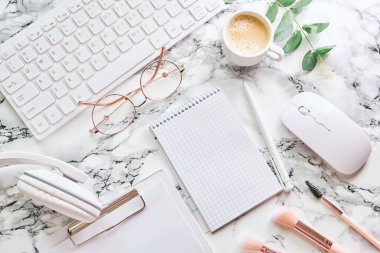 Düz uzanın, ofis masasında Girl 'ün elinde kahve var. Klavye, malzeme, mermer arka planda bir fincan kahve. Kozmetik blogu, kozmetik mağazası. Üst görünüm