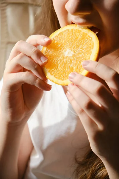 stock image A kid girl eats an orange slice, close-up, without eyes. Vitamin nutrition, fruits