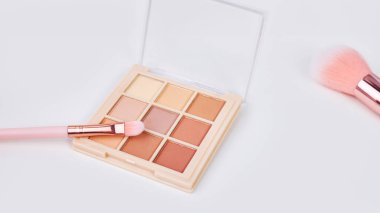 Geniş ekran arka plan dekoratif kozmetik seti beyaz bir masa, fırçalar ve göz farı. Makyaj odasındaki makyaj masasında dekoratif kozmetik ürünler.