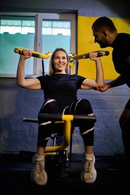 Koyu renk bir spor salonunda spor salonunda spor yaparken spor aletini kullanmasına yardımcı olan özel koç.