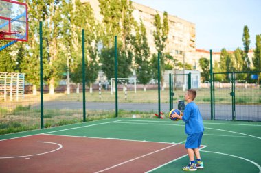 Oyun sahasında basketbol oynayan neşeli, genç bir çocuk. Çocuk, şehir binalarının arka planına karşı Red Court 'ta sahne alıyor. Aktif yaşam tarzı, eğitim, profesyonel spor