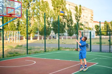 Oyun sahasında basketbol oynayan neşeli, genç bir çocuk. Çocuk, şehir binalarının arka planına karşı Red Court 'ta sahne alıyor. Aktif yaşam tarzı, eğitim, profesyonel spor