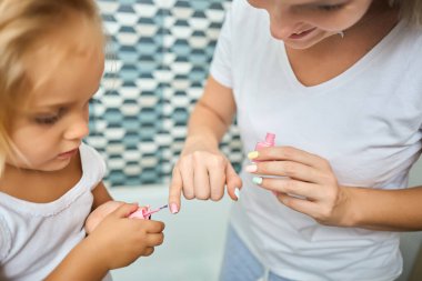 Anne ve kızı evde birlikte manikür yapıyorlar. Aile, güzellik ve ebeveynlik, banyoda cilt bakımı konsepti