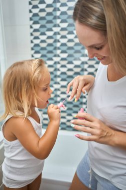 Anne ve kızı evde birlikte manikür yapıyorlar. Aile, güzellik ve ebeveynlik, banyoda cilt bakımı konsepti