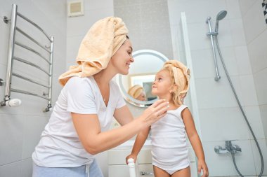 Banyoda mutlu bir aile. çocuk kızı bir havlu kuru saçlar ile anne