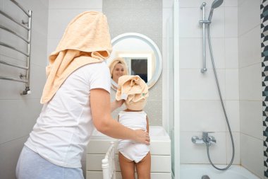 Banyoda mutlu bir aile. çocuk kızı bir havlu kuru saçlar ile anne