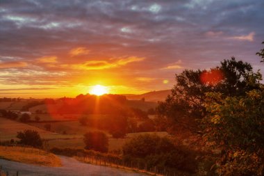 Bulutlu gökyüzündeki Fransız tepelerinin üst manzarası. Güneş doğarken Chemin du Puy boyunca doğa manzarası. Aziz James 'in yolu. Ostabat, Fransa