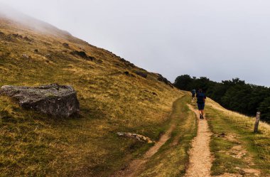 Pilgrims from behind along the Camino de Santiago. Path of the way of St James in the French Pyrenees