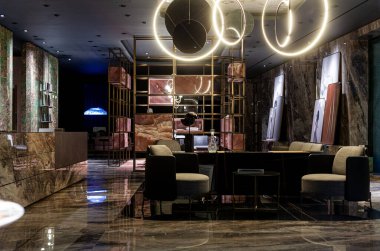Elegant and dark apartment interior with elegant furniture and a large neon light on the ceiling