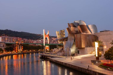 Bilbao, İspanya - 02 Ağustos 2022: Günbatımı modern ve çağdaş sanat Guggenheim Müzesi ve La Salve Köprüsü