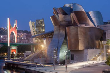 Bilbao, İspanya - 02 Ağustos 2022: Günbatımı modern ve çağdaş sanat Guggenheim Müzesi ve La Salve Köprüsü