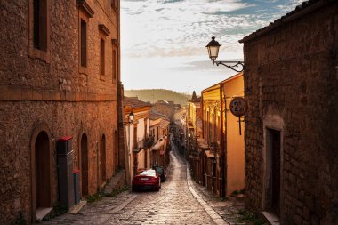 Street with old houses of Aidone at sunset in the Enna province, Sicily in Italy clipart