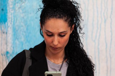 Milan, İtalya - 22 Nisan 2023: Alcova Ex Mattatoio 'daki Milan Tasarım Haftası 2023 sergisi sırasında telefonuna mesaj yazan genç kadın