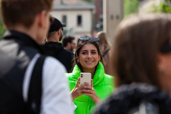 意大利米兰 2023年4月22日 一名身穿绿色无袖夹克的年轻女子在2023年米兰设计周期间与她的手机拍照 — 图库照片