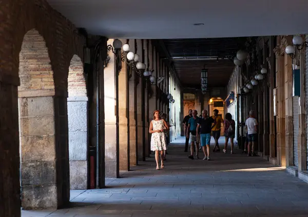 Pamplona, İspanya - 01 Ağustos 2022: Pamplona 'daki tarihi Plaza del Castillo Meydanı yakınlarındaki Kemer sütununda yürüyen insanlar