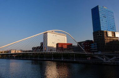 Bilbao, İspanya - 02 Ağustos 2022: Nervion Nehri ve Zubizuri Köprüsü. Gün batımında Bilbao nehri manzarası