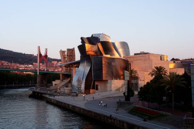 Bilbao, İspanya - 2 Ağustos 2022: Amerikan mimar Frank Gehry tarafından tasarlanan ve Ekim 1997 'de hizmete giren modern ve çağdaş sanat eseri Guggenheim Müzesi' nin günbatımı.