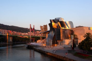 Bilbao, İspanya - 02 Ağustos 2022: Günbatımı modern ve çağdaş sanat Guggenheim Müzesi ve La Salve Köprüsü
