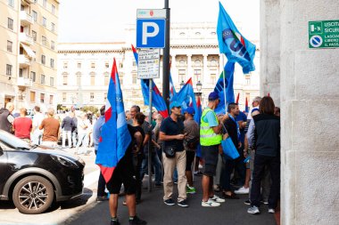 Trieste, İtalya - 03 Eylül 2022: Wartsila grubundan işçilerin işten çıkarılmasına karşı düzenlenen gösteri sırasında İtalyan UIL ve UILM Birliği bayraklarıyla protestocular.