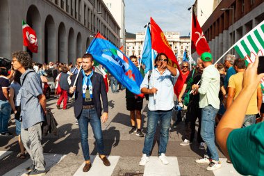 Trieste, İtalya - 03 Eylül 2022: Wartsila Grou 'daki işçilerin işten çıkarılmasına karşı düzenlenen gösteri sırasında Birleşik İtalyan Sendikaları bayraklarıyla protestocular