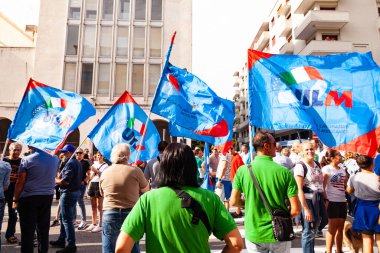 Trieste, İtalya - 03 Eylül 2022: Wartsila grubundan işçilerin işten çıkarılmasına karşı düzenlenen gösteri sırasında İtalyan UIL ve UILM Birliği bayraklarıyla protestocular.