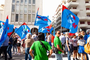 Trieste, İtalya - 03 Eylül 2022: Wartsila grubundan işçilerin işten çıkarılmasına karşı düzenlenen gösteri sırasında İtalyan UIL ve UILM Birliği bayraklarıyla protestocular.
