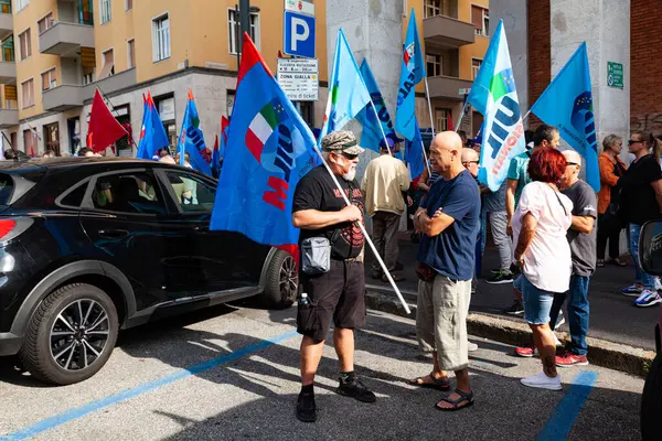 Trieste, İtalya - 03 Eylül 2022: Wartsila grubundan işçilerin işten çıkarılmasına karşı düzenlenen gösteri sırasında İtalyan UIL ve UILM Birliği bayraklarıyla protestocular.